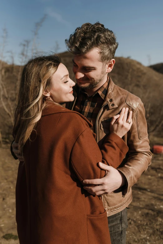 a man in a leather jacket hugs his partner