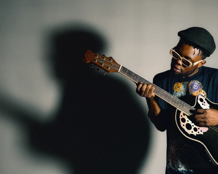 a man wearing glasses plays on his guitar