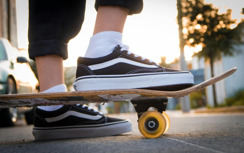 someone wearing vans shoes while standing on top of a skateboard