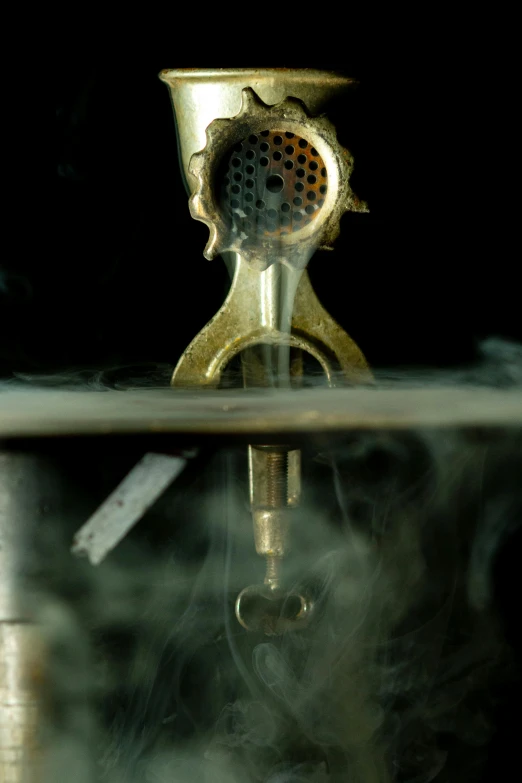 a closeup s of a propane burner with smoke coming from the bottom