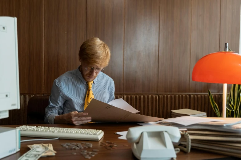 a woman sitting at a desk looking at papers