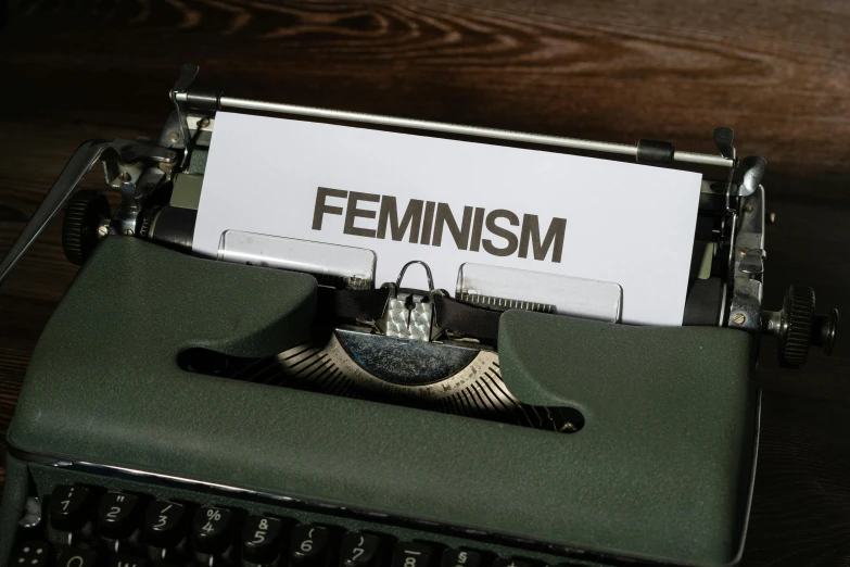a female feminist is posted in a paper on an old typewriter