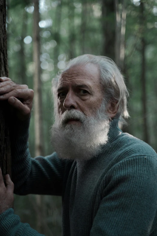 a man holding the bark of a tree in the woods