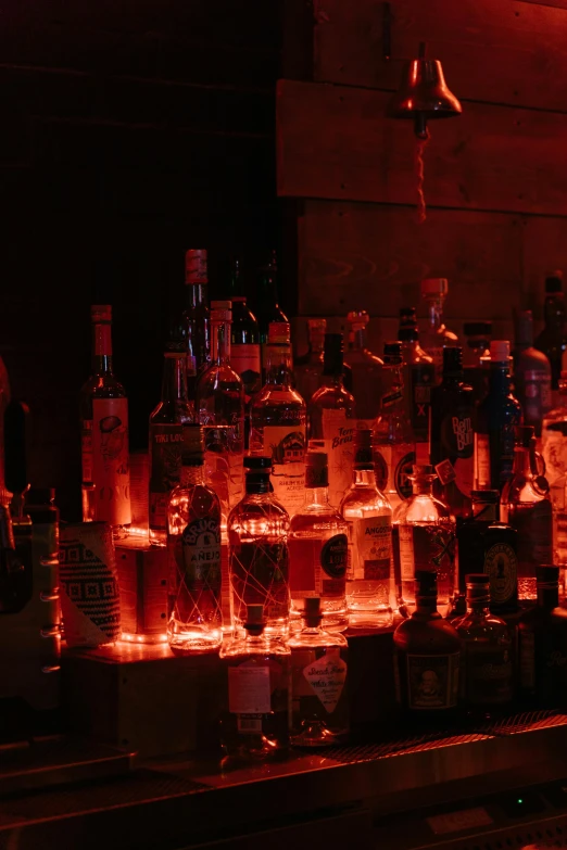 a shelf filled with alcohol bottles and some lit candles