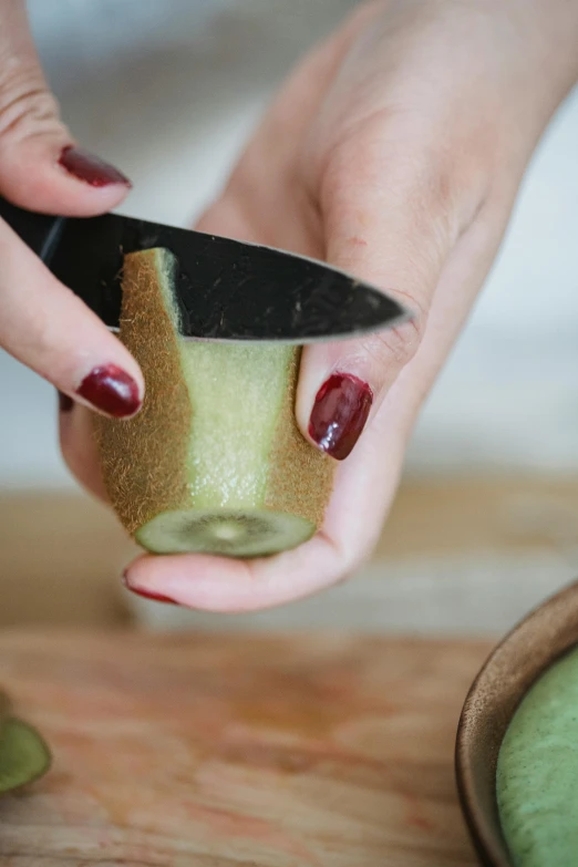 a person cuts into a apple with a knife