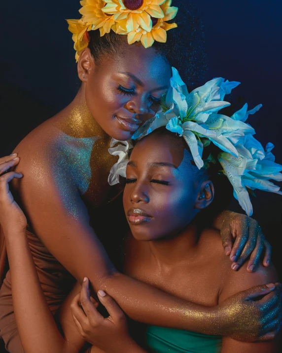 two girls covered with gold body paint pose for a po