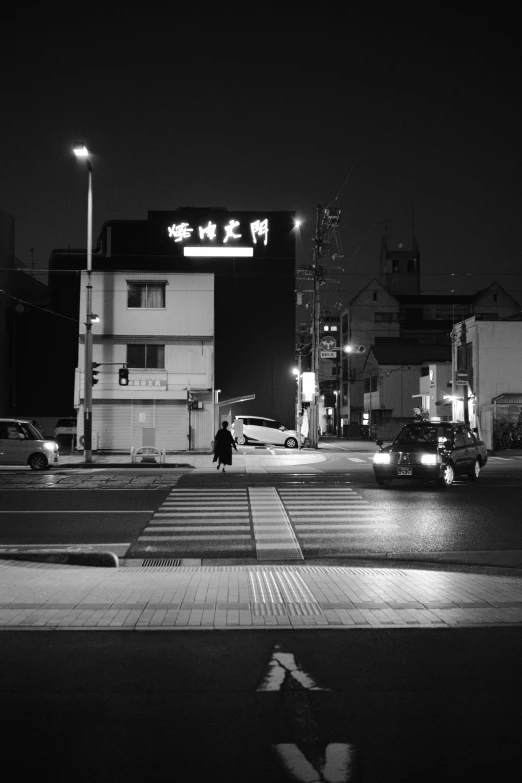 black and white pograph of a lit parking lot at night