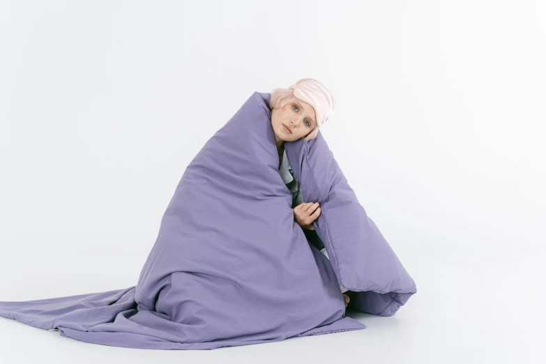 a man wrapped up in a purple blanket