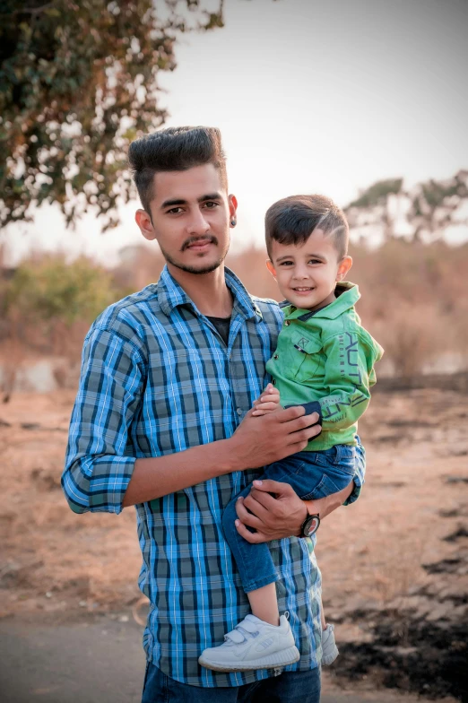 a man holding a child is standing outside