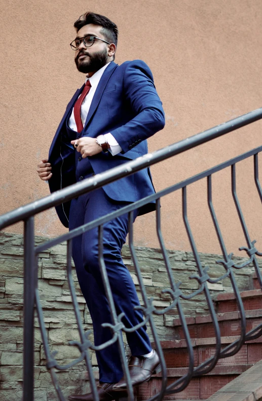 man with blue suit and red tie on stairs