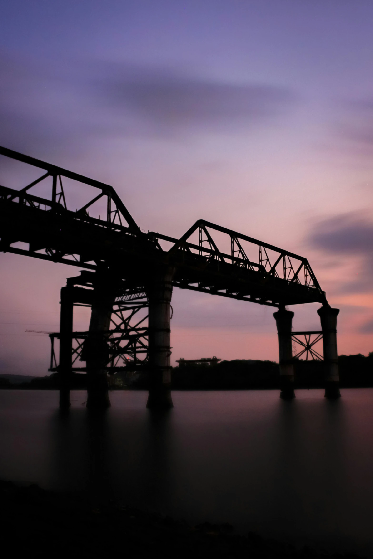 there is a train bridge that stretches over the water