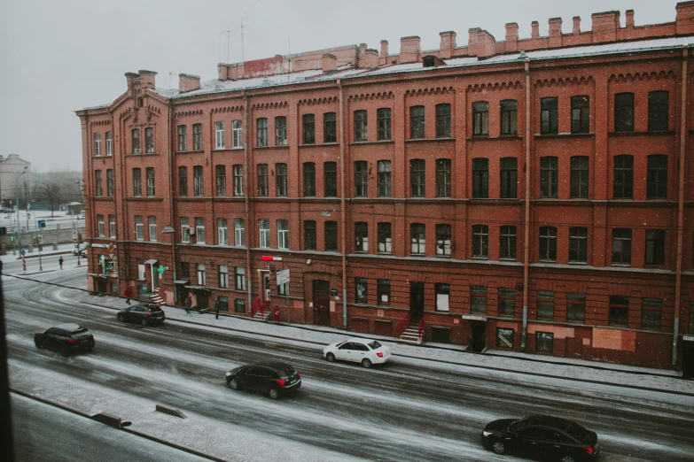 a bunch of cars traveling on the street in heavy winter snow