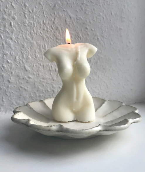a candle sits in a small white bowl