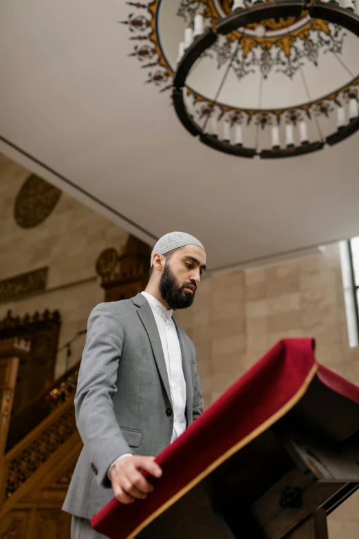 a man in a turban stands behind a casket and holds it