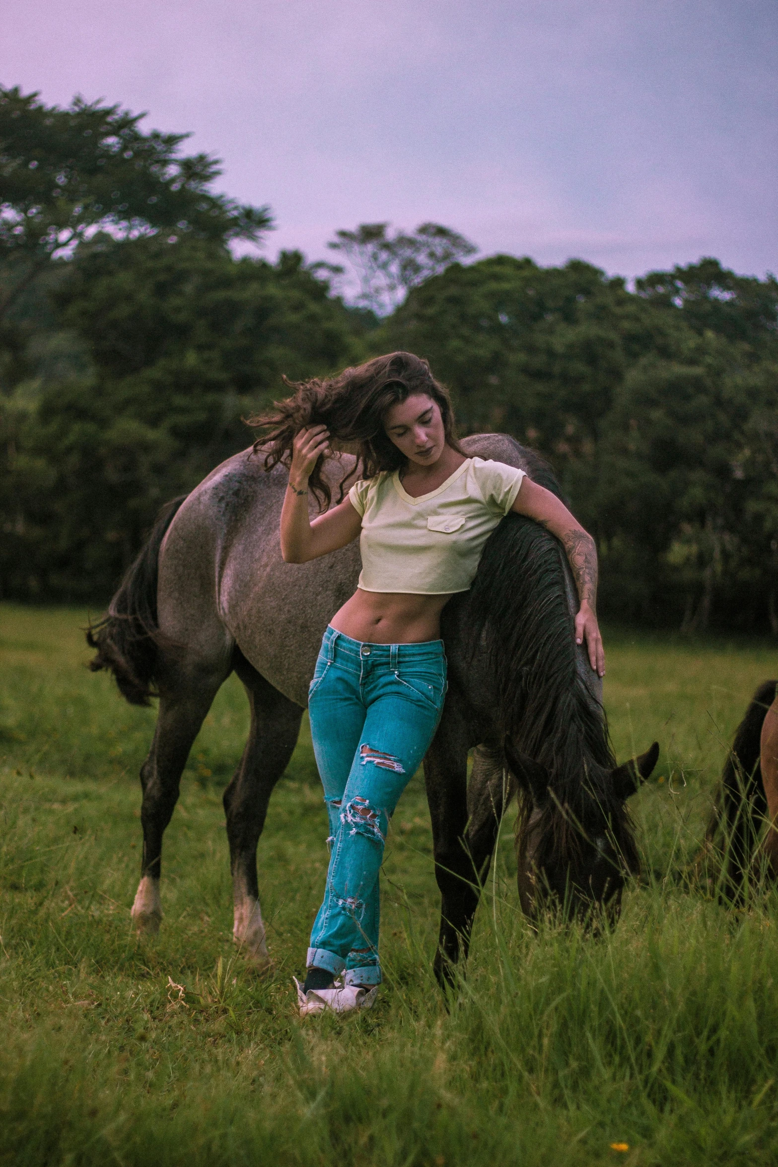 a woman is posing next to a horse