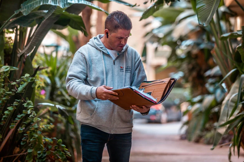 a man walks through an open book with foliage