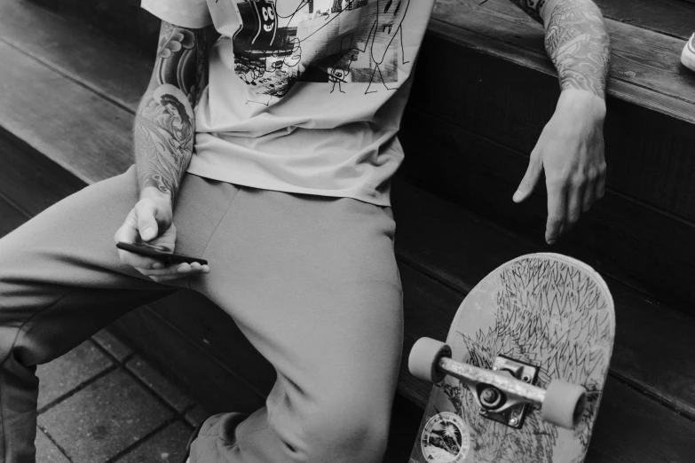 a young man sitting on a bench with a skateboard in hand