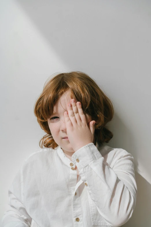 a child covering her eyes with hands with their palms