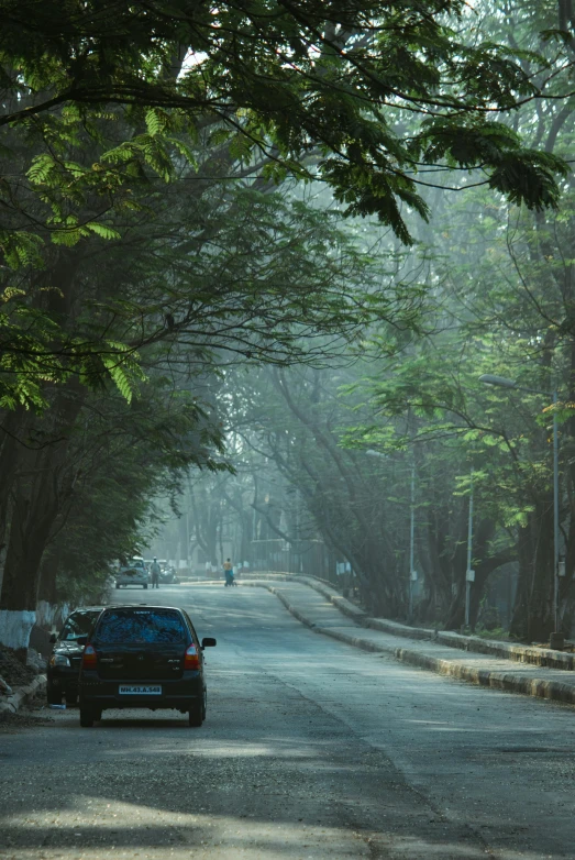 an image of car driving in the middle of the street