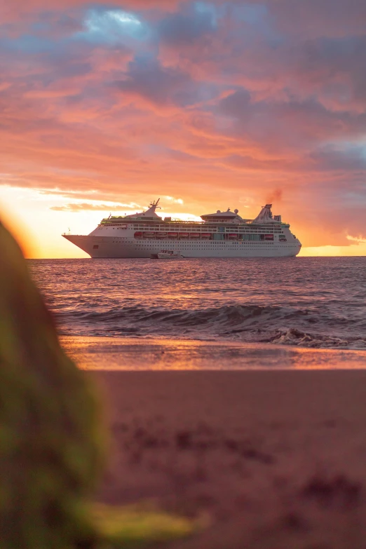 the cruise ship sails through a cloudy sunset