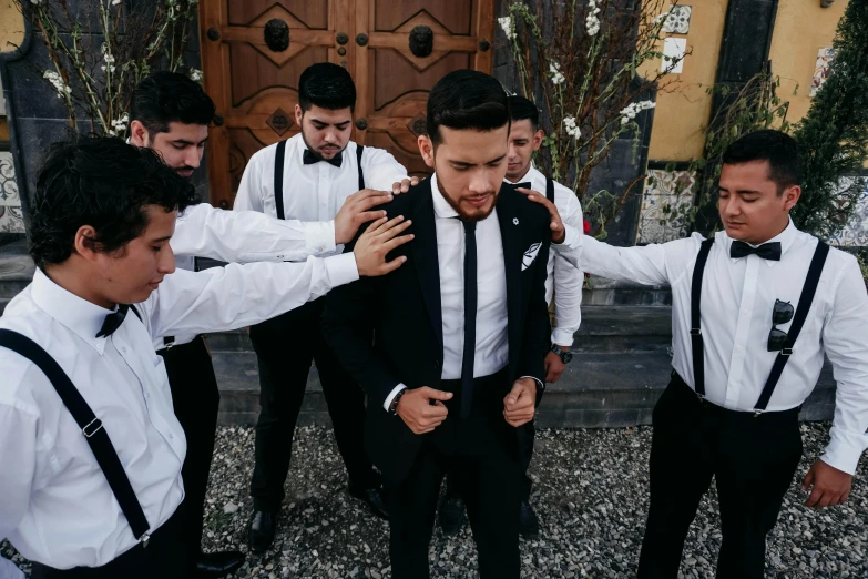 several men wearing black ties and white shirts standing together