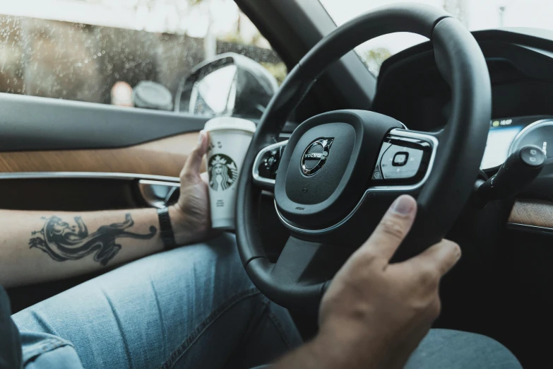 a man in jeans and a white t - shirt driving a vehicle