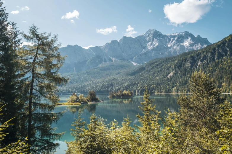 a small island sits surrounded by mountains and lake