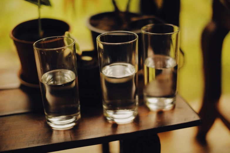 three glasses on a table that are half empty