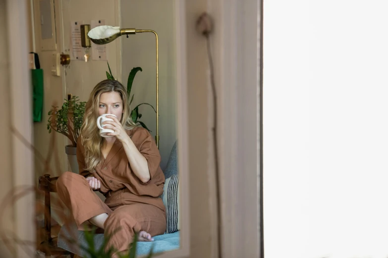 a young lady sitting on a chair drinking soing