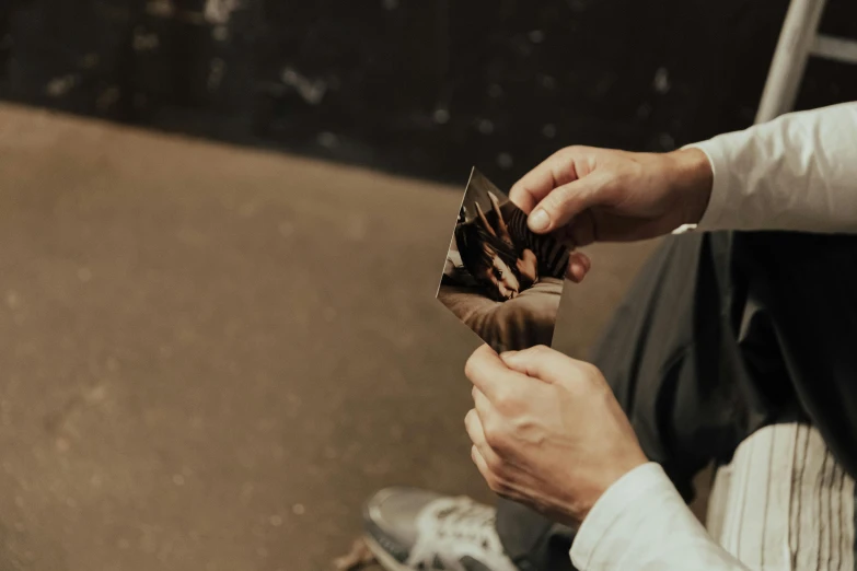 a person sitting down holding soing with their fingers