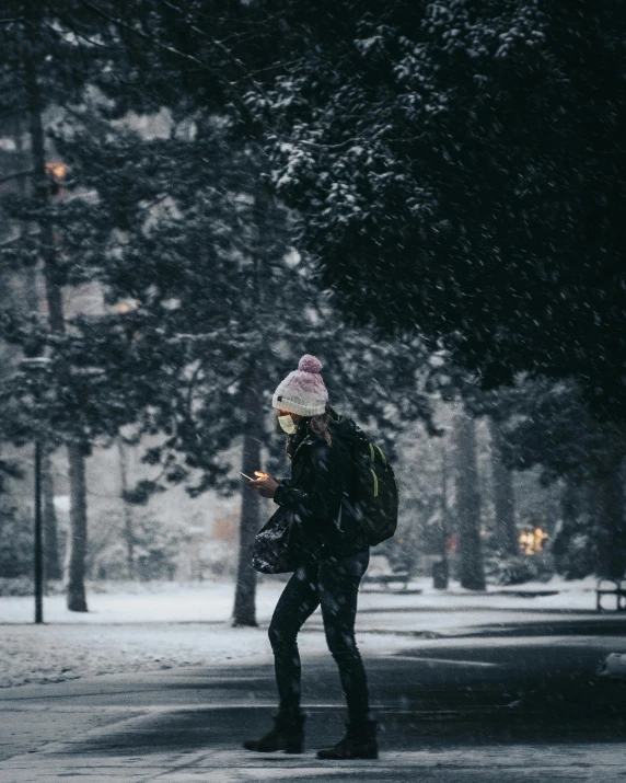 a woman walking down a snow covered street