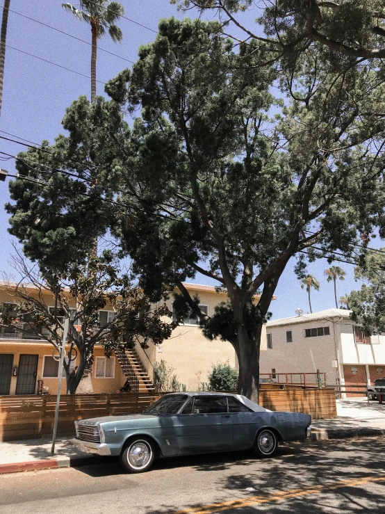 an old car is parked near a tree