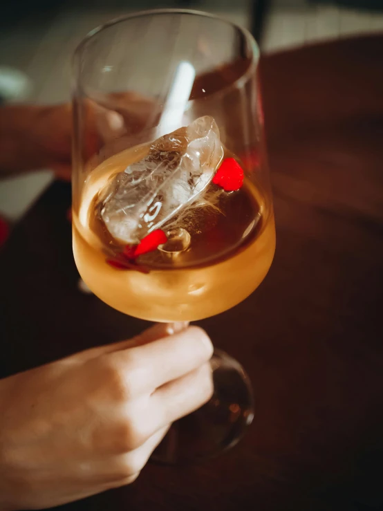 a person holding a glass with a drink on it