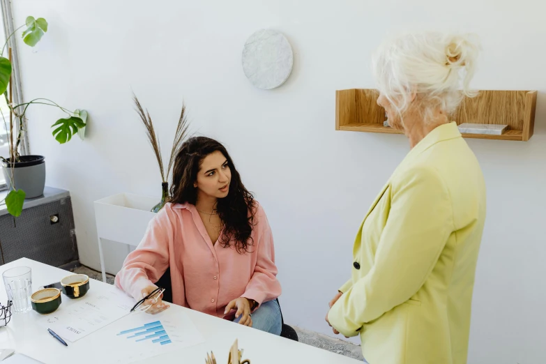 two women sitting at a table talking and having conversation