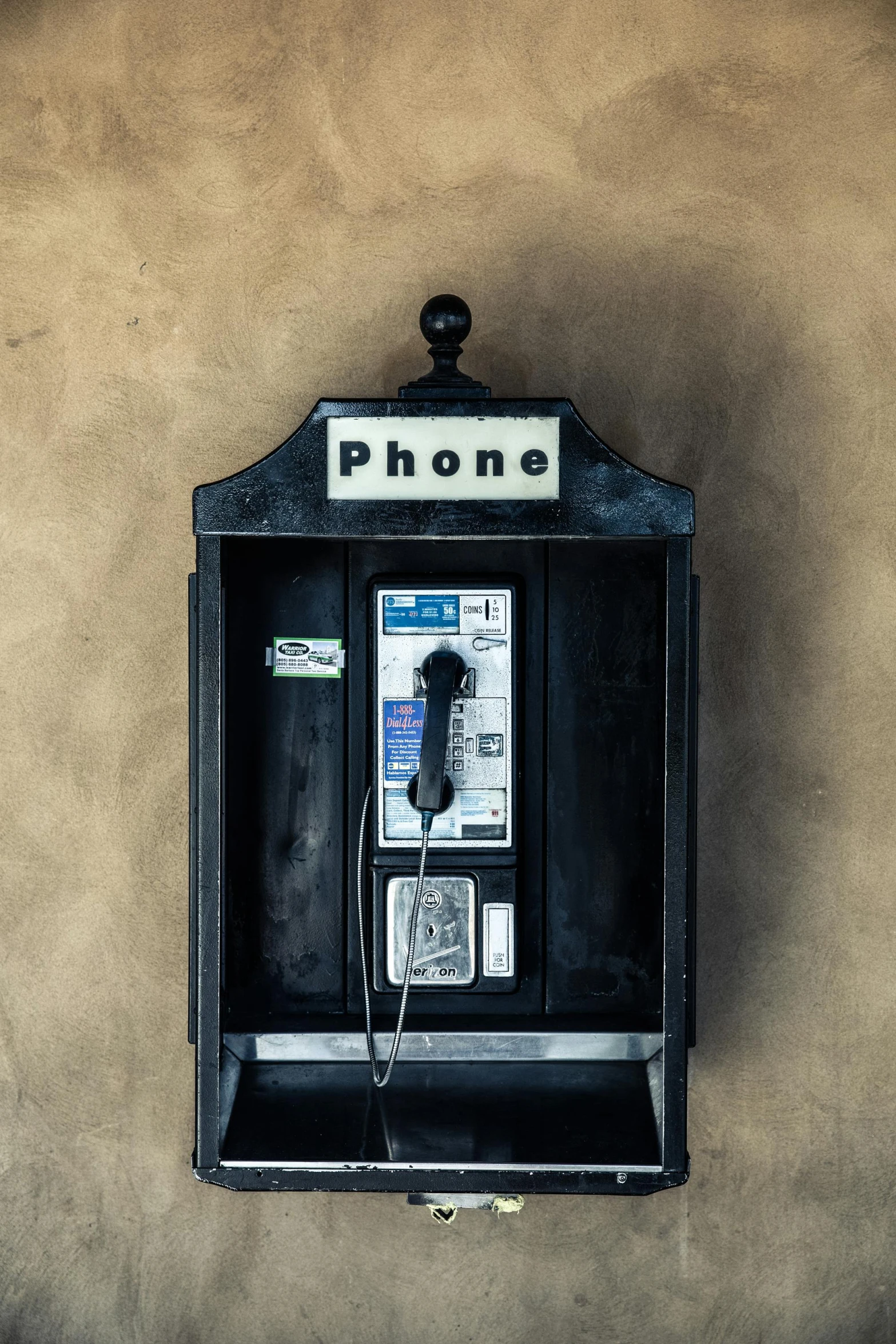 a phone booth on a wall next to a wall with a sign