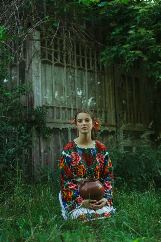 a woman kneeling down in a grassy field