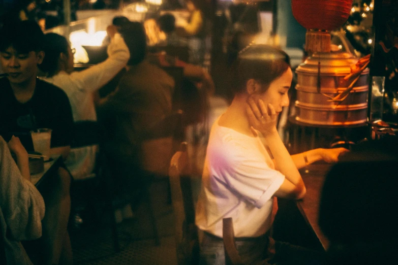 a girl standing at a bar holding her phone