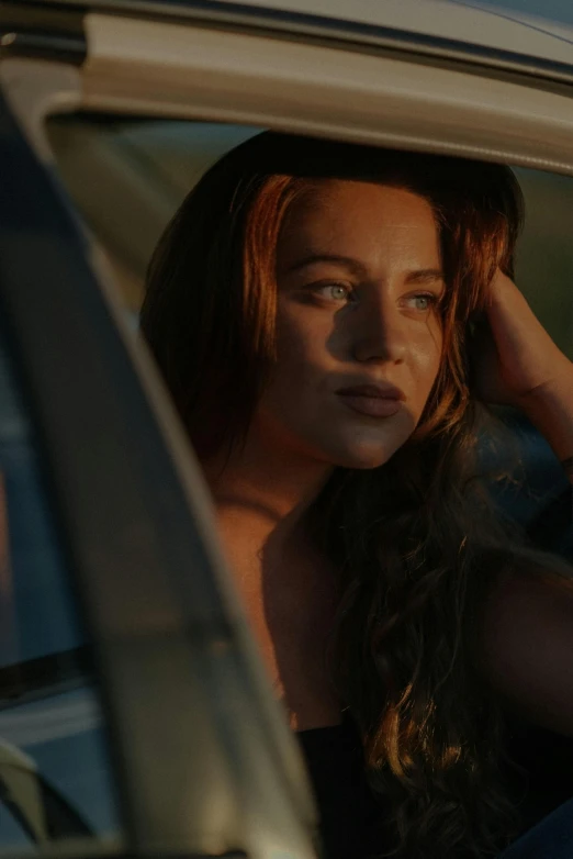 a woman sitting in a car looking out the window