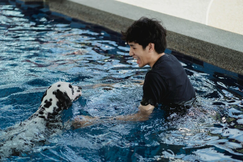 a man that is in the water with a dalmatian