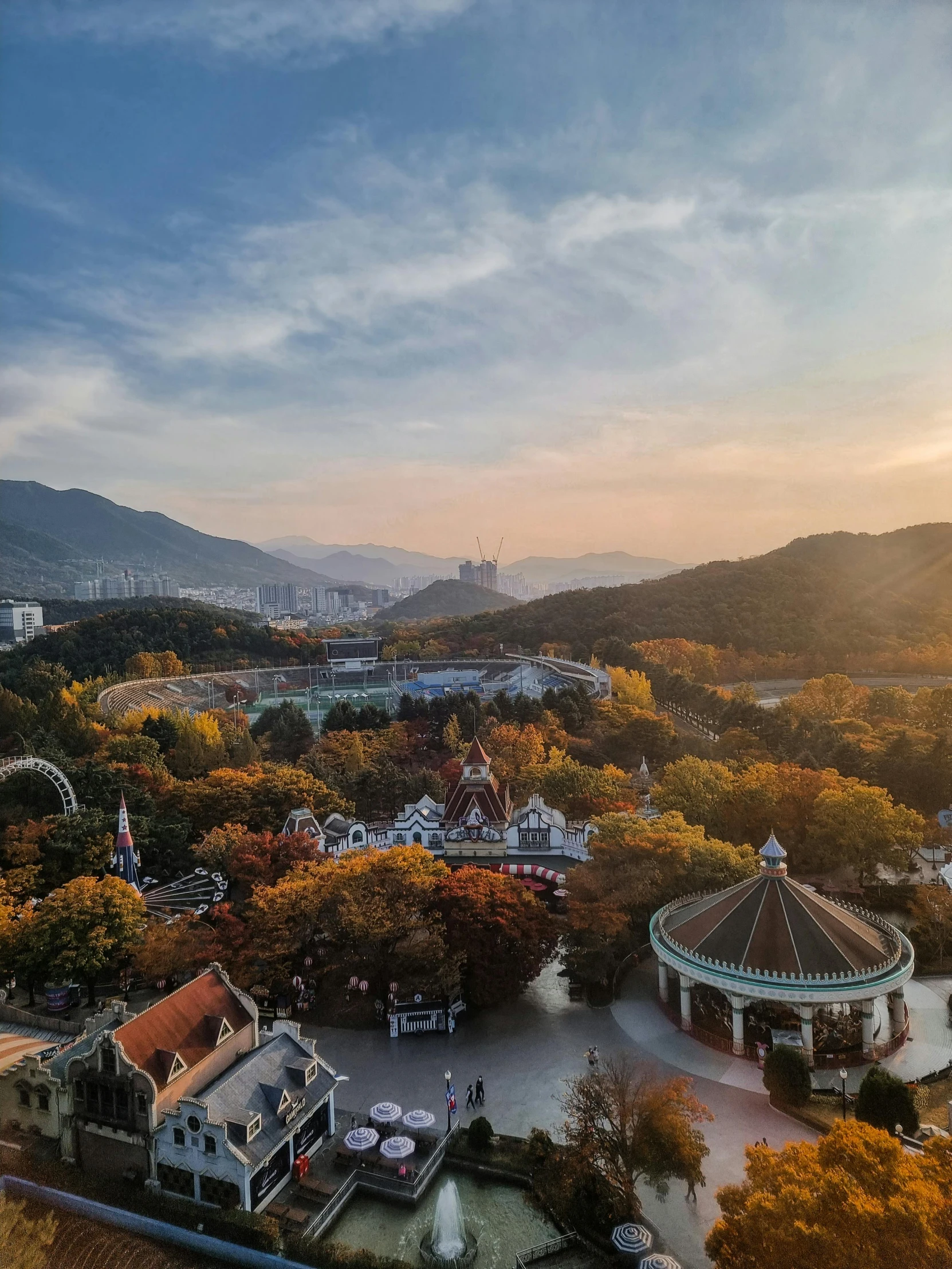 aerial view of trees and small buildings with mountains in background