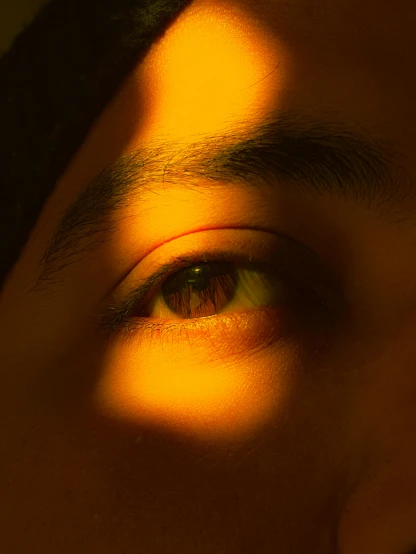 a man's eye with long shadows on the face