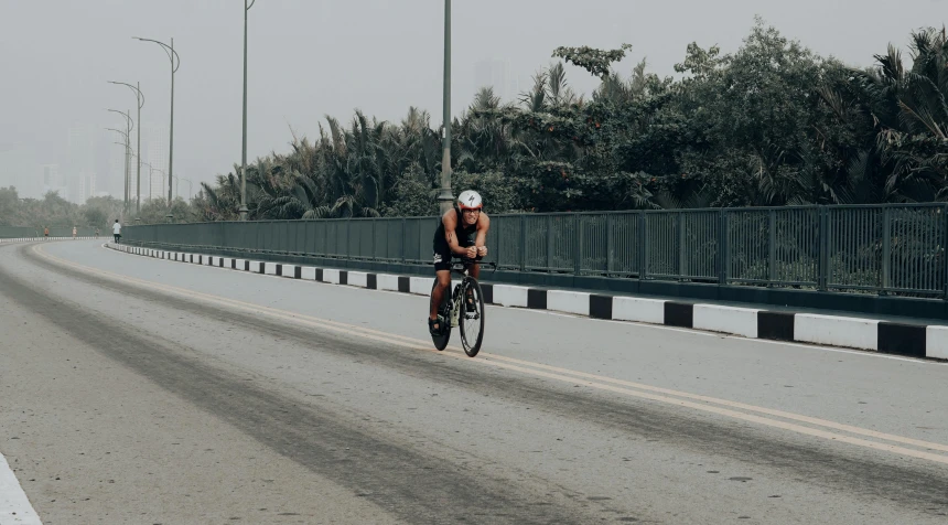 man with helmet riding on bicycle down the highway