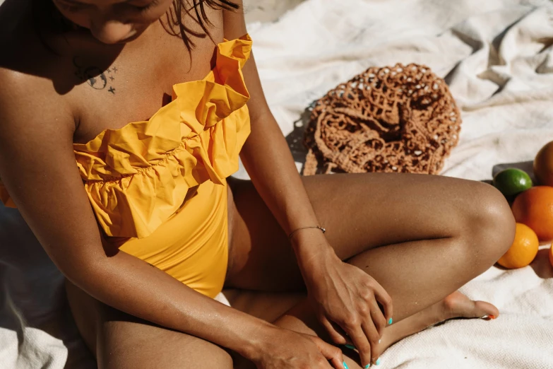 a woman is wearing a yellow swimsuit on the beach