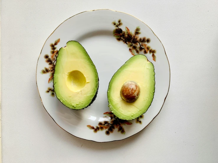 an avocado cut in half on a plate