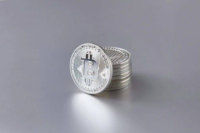 a stack of silver coins on a silver surface