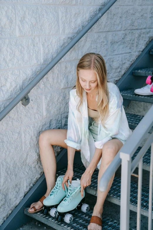 woman with blue shoes looking down at pair of sneakers