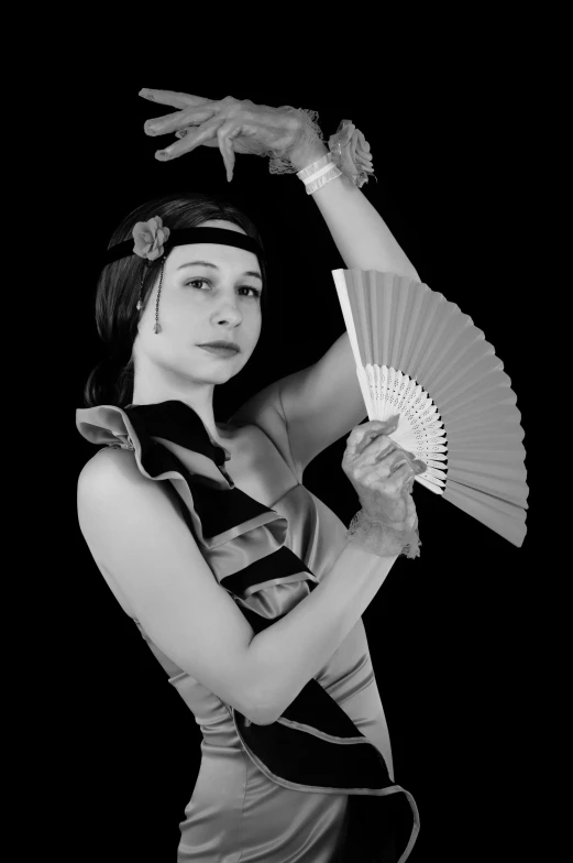a woman holding a fan is posed for a po