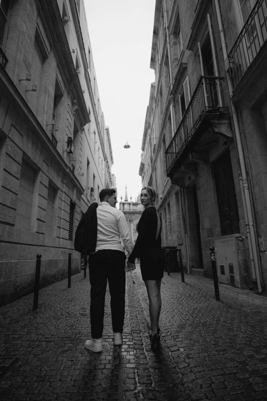two people walk in an alley between two buildings