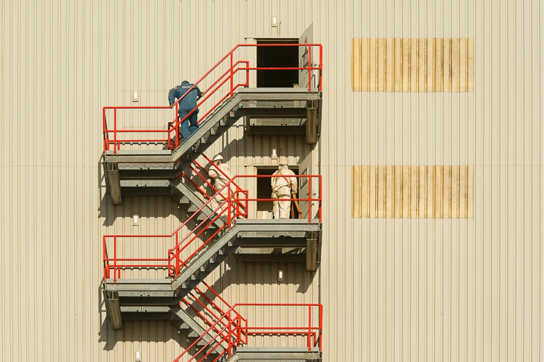 an aerial view of men standing outside a building that is painted red