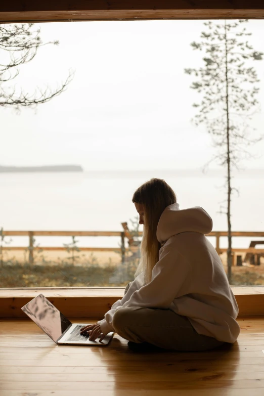 a person sitting on the floor with their laptop